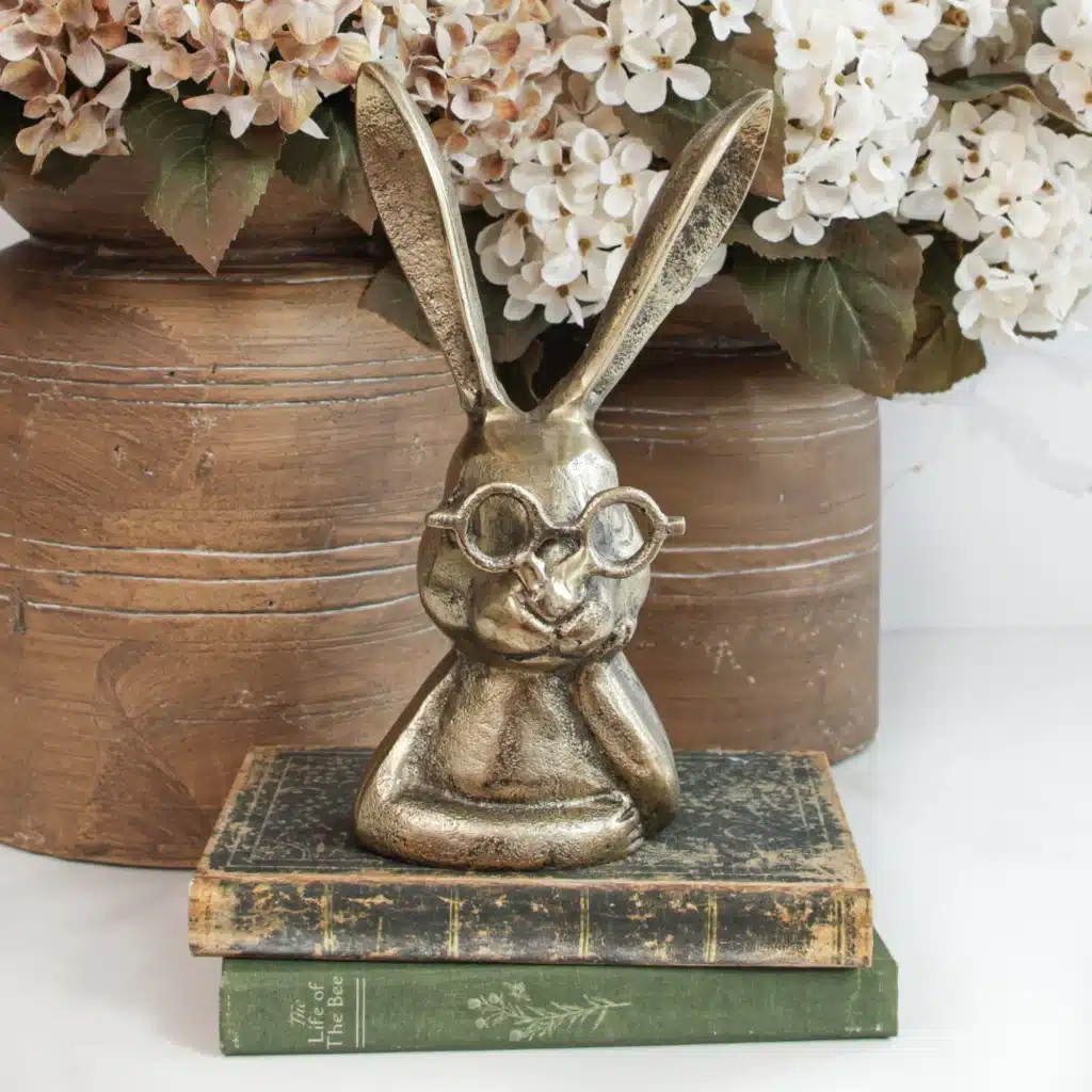 Interior Delights client highlight: brass rabbit figurine with glasses atop antique books