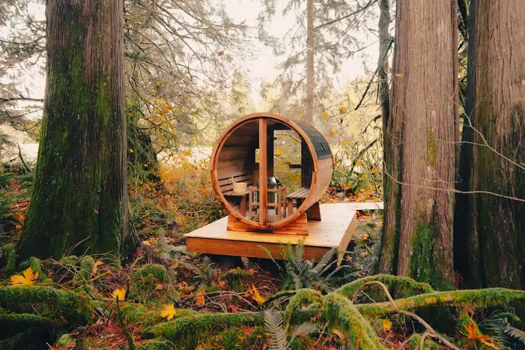 Sun Valley Saunas client highlight: barrel sauna on a wooden deck in a mossy forest