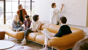 A team sketches an ecommerce planning flow diagram on a whiteboard in a casual office