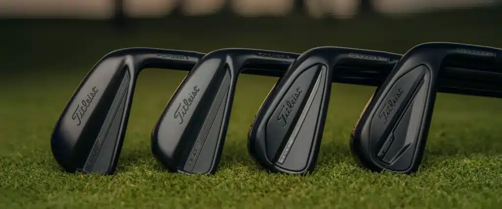TGW client highlight: set of black golf iron clubheads lined up on turf