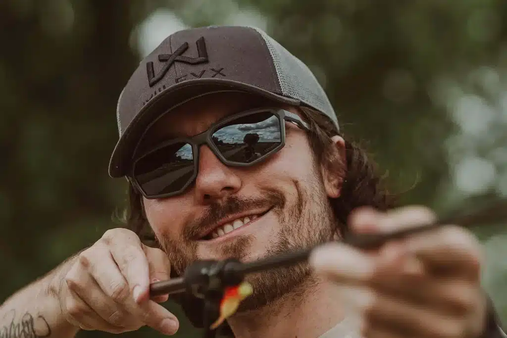 Wiley X client highlight: angler in sunglasses and cap tying a fishing lure